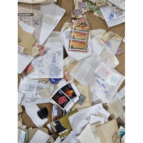 202 - A red hold bag containing a very large quantity of assorted loose stamps to include British stamps, ... 
