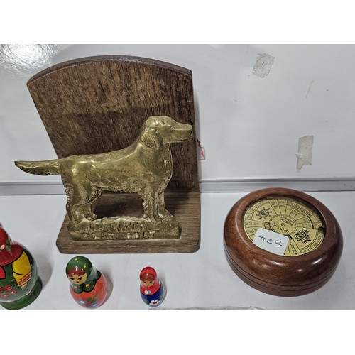 215 - A shelf full of collectables to include a vintage Morris hubcap in chrome, a cased photograph viewer... 