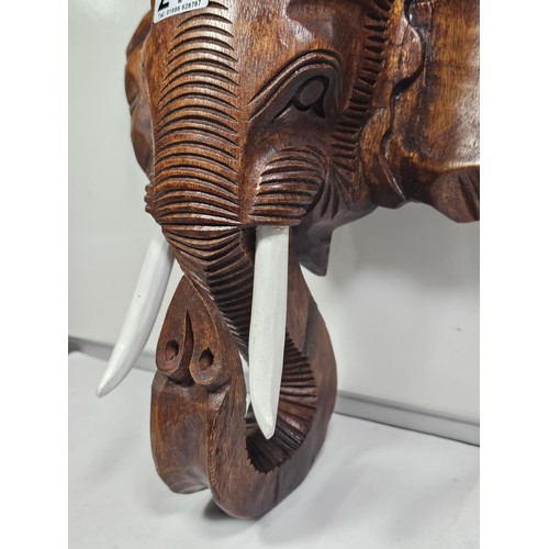 219 - A good quality solid wood hand carved elephant head figure with good detailing to the face and front... 