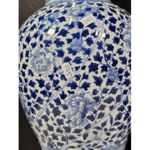 235 - A pair of Chinese blue and white lidded vases decorated with dense floral patterns in under glazed c... 