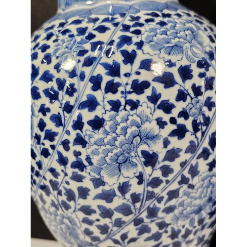 235 - A pair of Chinese blue and white lidded vases decorated with dense floral patterns in under glazed c... 