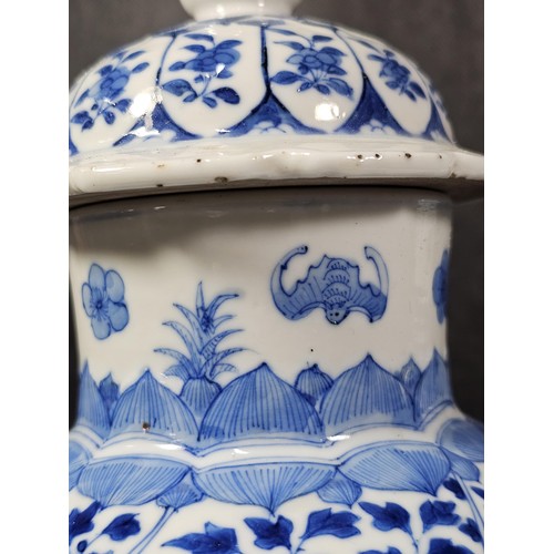 235 - A pair of Chinese blue and white lidded vases decorated with dense floral patterns in under glazed c... 