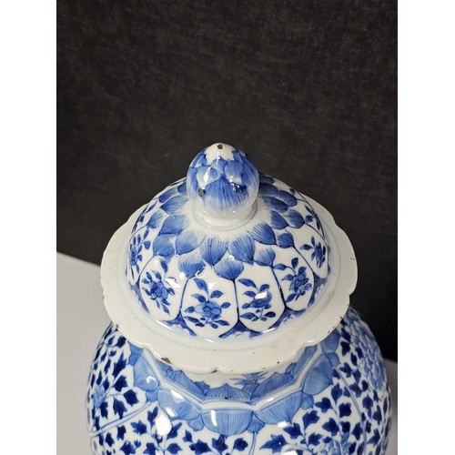 235 - A pair of Chinese blue and white lidded vases decorated with dense floral patterns in under glazed c... 
