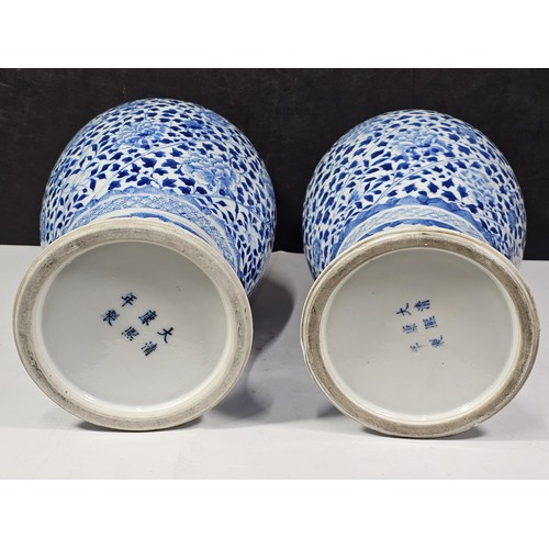 235 - A pair of Chinese blue and white lidded vases decorated with dense floral patterns in under glazed c... 