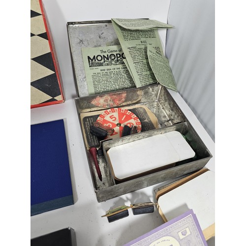 18 - A Collection of vintage games to include a tin containing a vintage Monopoly game dating from the 19... 
