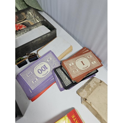 18 - A Collection of vintage games to include a tin containing a vintage Monopoly game dating from the 19... 