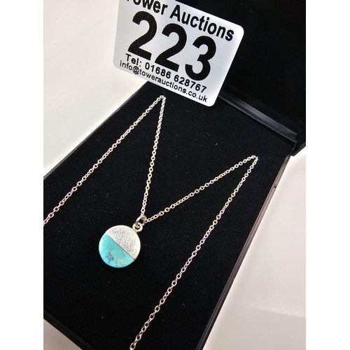 223 - A designer 925 silver pedant necklace by Oliver Bonas featuring a silver disk pendant, set with a tu... 