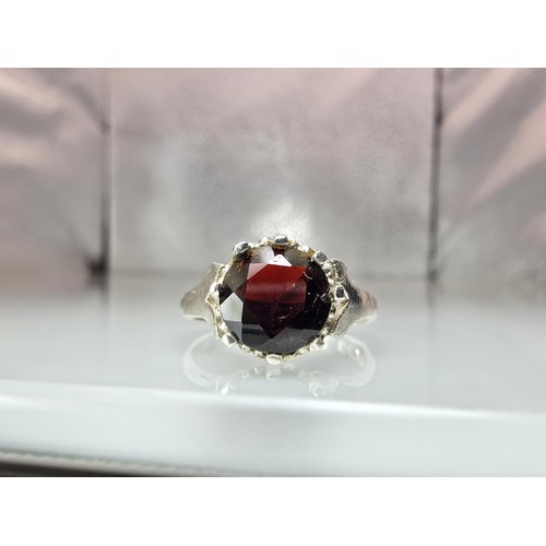 202 - A good quality vintage hallmarked silver solitaire ring set with a large round cut faceted garnet ge... 