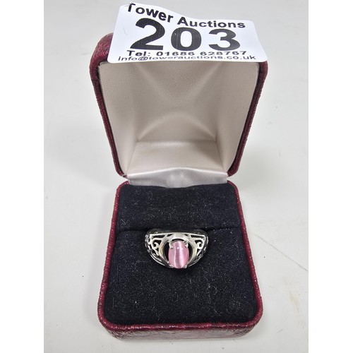 203 - An attractive 925 silver ring, having pierced shoulders, set with an attractive pink cats eye type c... 