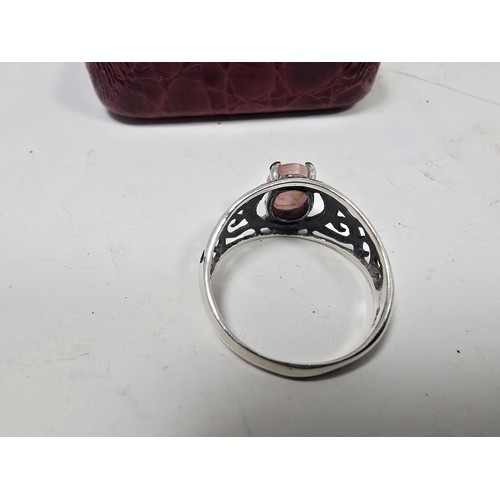 203 - An attractive 925 silver ring, having pierced shoulders, set with an attractive pink cats eye type c... 