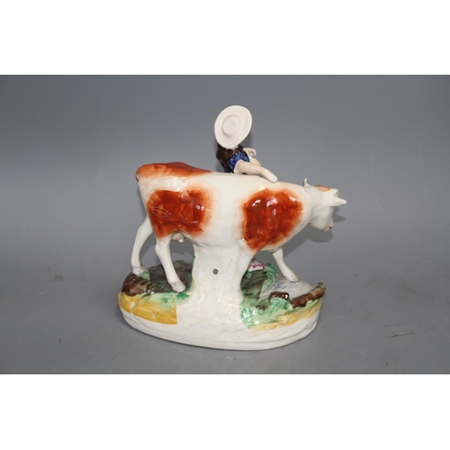 116 - A Staffordshire pottery group of a milkmaid and cow, L. 21cm Condition: Loss to cow's right horn and... 