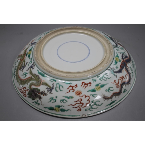 130 - A Chinese famille verte 'dragon' dish, 39cm Condition: A few small rim chips and some scratching to ... 