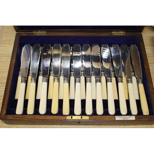 140 - A cased set of twelve pairs of plated fish knives and forks with servers, silver banded ivorine hand... 