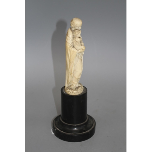 18 - A 19th century Dieppe carved ivory figure of St Joseph holding the Christ child, 16cm, on ebony socl... 