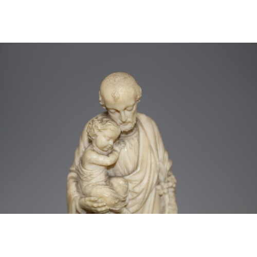 18 - A 19th century Dieppe carved ivory figure of St Joseph holding the Christ child, 16cm, on ebony socl... 