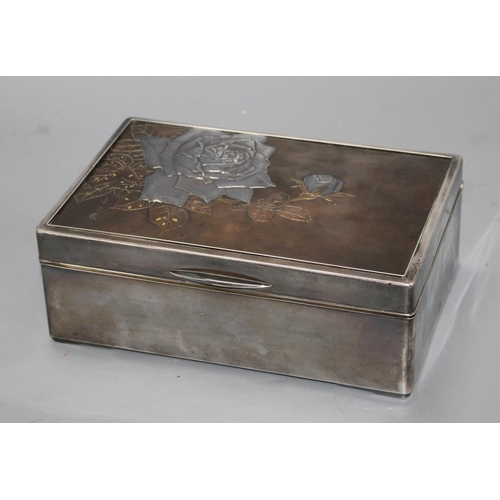 22 - A Japanese silver, copper and gold cigarette box, Meiji period, decorated with a panel of roses, sig... 