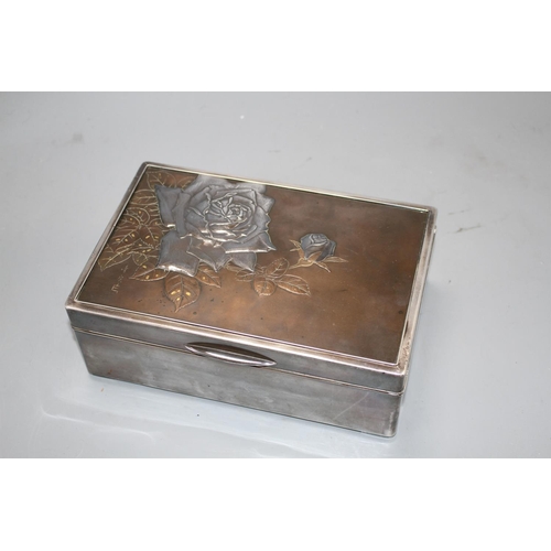 22 - A Japanese silver, copper and gold cigarette box, Meiji period, decorated with a panel of roses, sig... 