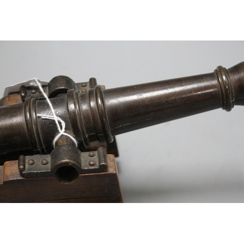 25 - An early 20th century bronze model of a Naval cannon, on wooden trunnion base, length 25cm Condition... 