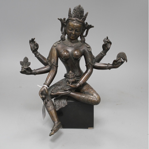 29 - A Sino-Tibetan bronze figure of a seated female deity, on associated marble plinth, height 35cm Cond... 