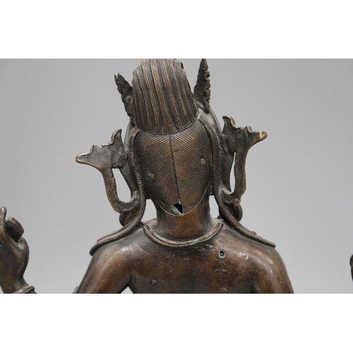 29 - A Sino-Tibetan bronze figure of a seated female deity, on associated marble plinth, height 35cm Cond... 