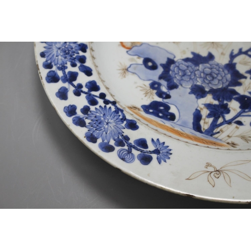 34 - A Chinese grisaille and underglaze blue dish, c.1740, decorated with birds, bamboo, rocks and flower... 