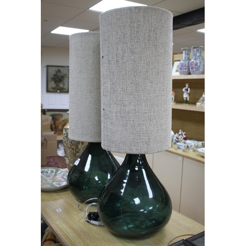 52 - A pair of green glass lamp bases with cylindrical fabric shades, height overall 94cm, diameter 34cm ... 