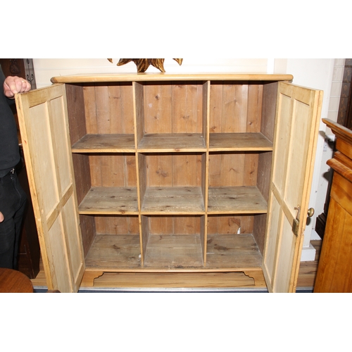 886 - An Edwardian pine boot cupboard, with two panelled doors enclosing a fixed nine division interior, W... 