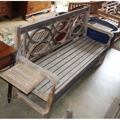 1053 - A weathered teak garden bench with detachable end drink holders, W.182cm, D.52cm, H.92cm