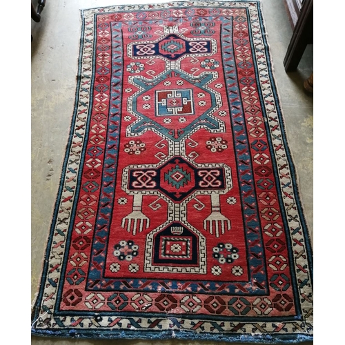 1056 - A Caucasian Kazak brick red ground rug, 178 x 102cm