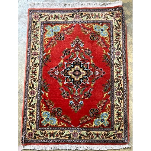 1117 - A Qum red ground rug, 100 x 74cm