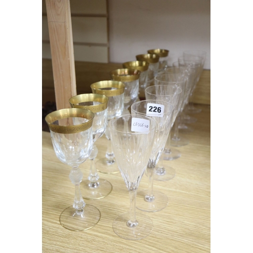 1226 - A set of seven gilt rimmed wine glasses and eight glass flutes