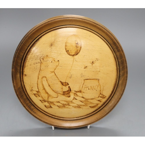 1230 - A poker work plaque of Winnie the Pooh, diameter 24.5cm