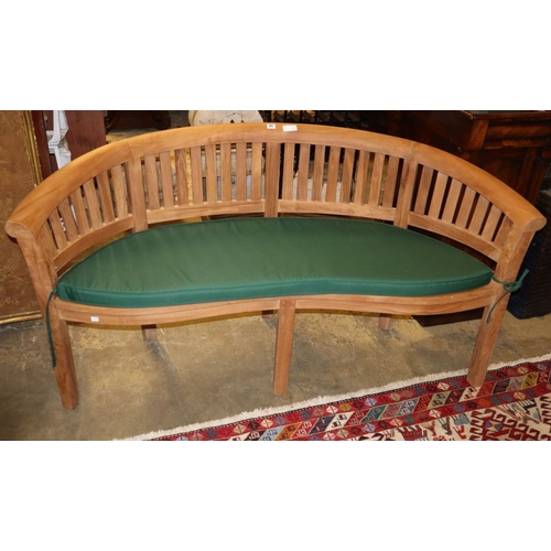 25 - A teak garden banana bench with green cushion seat, W.160cm, D.56cm, H.83cm