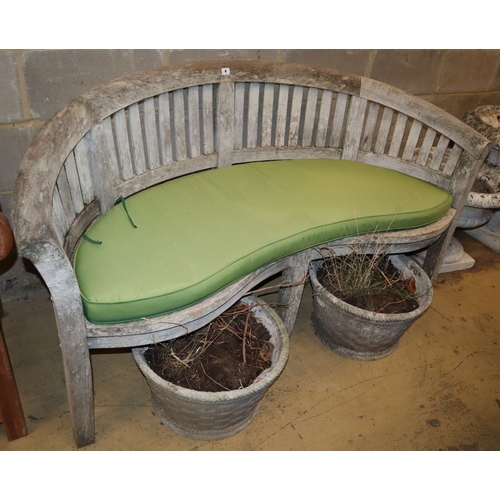 4 - A weathered teak garden banana bench with cushion, W.160cm, D.60cm, H.85cm