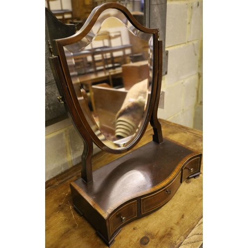 31 - A shield-shaped swing frame mahogany toilet mirror, cross-banded and line-inlaid, the serpentine-fro... 