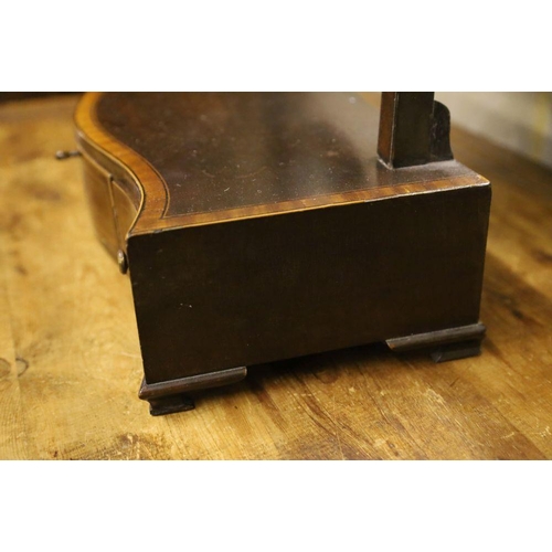 31 - A shield-shaped swing frame mahogany toilet mirror, cross-banded and line-inlaid, the serpentine-fro... 