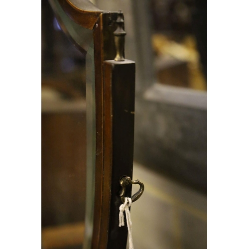 31 - A shield-shaped swing frame mahogany toilet mirror, cross-banded and line-inlaid, the serpentine-fro... 