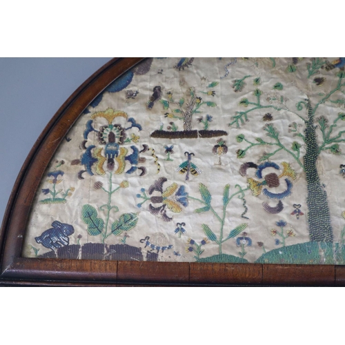 37 - A late 17th century silk and bead work arched panel, with central tree, birds, butterflies, exotic l... 