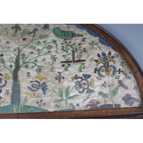 37 - A late 17th century silk and bead work arched panel, with central tree, birds, butterflies, exotic l... 