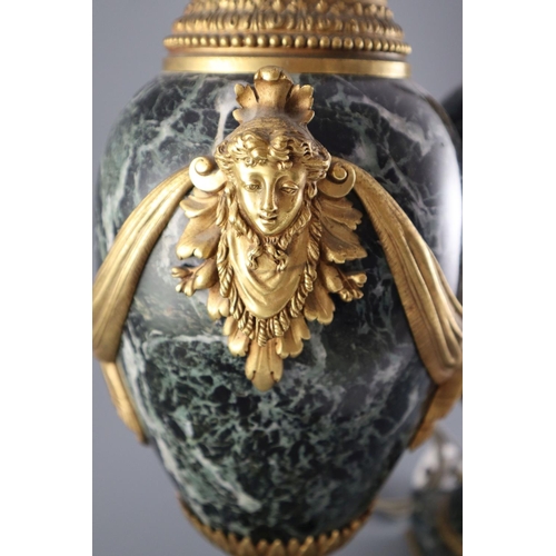 51 - A pair of early 20th century ormolu green marble table lamps, with ovular form with mask lug handles... 