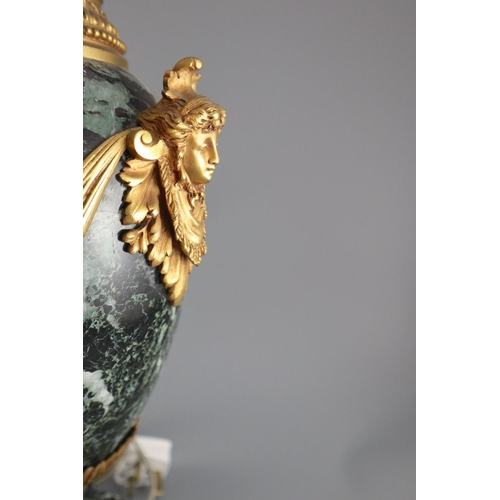 51 - A pair of early 20th century ormolu green marble table lamps, with ovular form with mask lug handles... 
