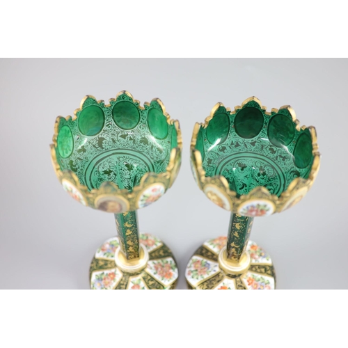 102 - A pair of Bohemian enamelled white overlaid green glass vases, late 19th century, with crenellated t... 