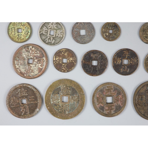 137 - China, a group of 26 bronze or brass charms or amulets, Qing dynasty, all with four character inscri... 