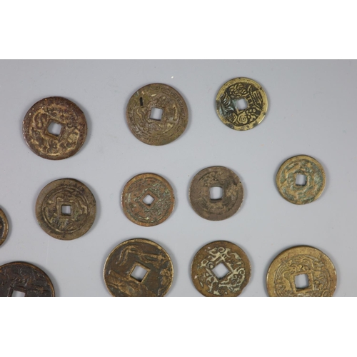 137 - China, a group of 26 bronze or brass charms or amulets, Qing dynasty, all with four character inscri... 