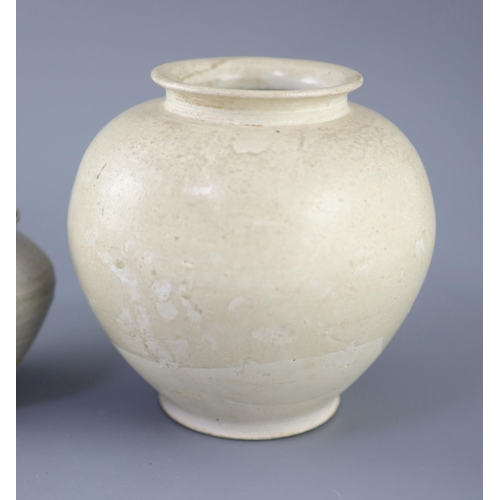 211 - A Chinese cream glazed ovoid jar, Tang dynasty and a Ding type jar and cover, Yuan dynasty, the larg... 