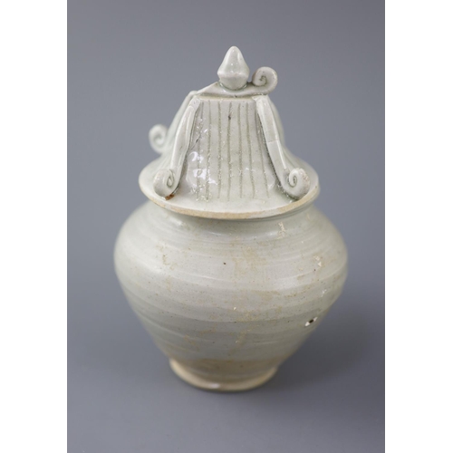 211 - A Chinese cream glazed ovoid jar, Tang dynasty and a Ding type jar and cover, Yuan dynasty, the larg... 