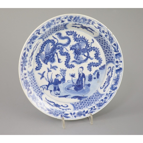 215 - A Chinese blue and white 'sage and phoenix' dish, Kangxi period, painted with the seated figure of a... 