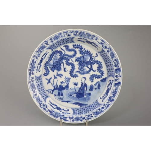 215 - A Chinese blue and white 'sage and phoenix' dish, Kangxi period, painted with the seated figure of a... 