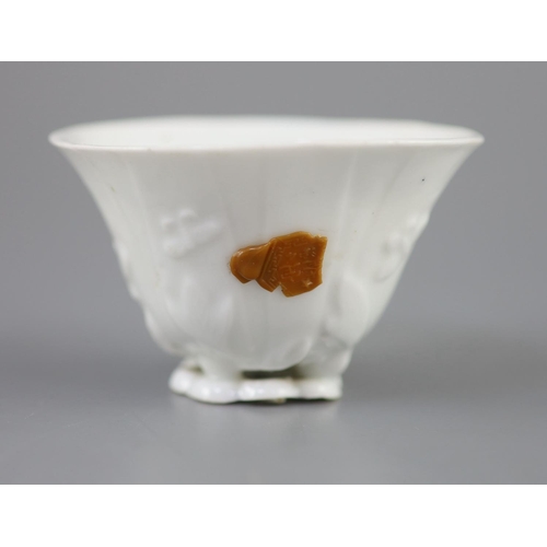 217 - A Chinese Dehua blanc de chine libation cup, moulded as a curled leaf with with leaves, buds and but... 