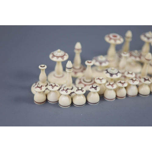 22 - A 19th century Muslim ivory chess set, the two sides with engraved red and brown geometric motifs, k... 